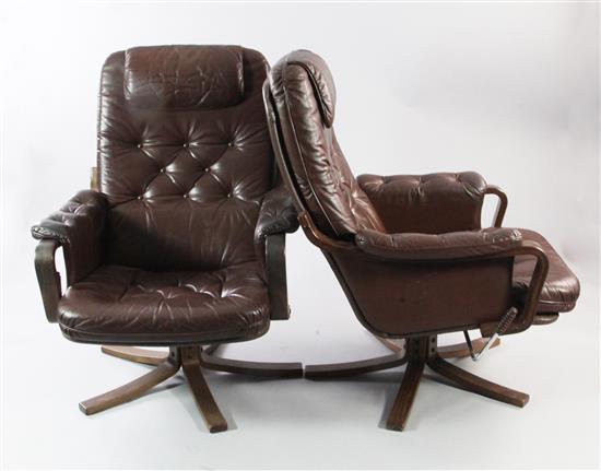 A pair of brown leather buttoned swivel armchairs,